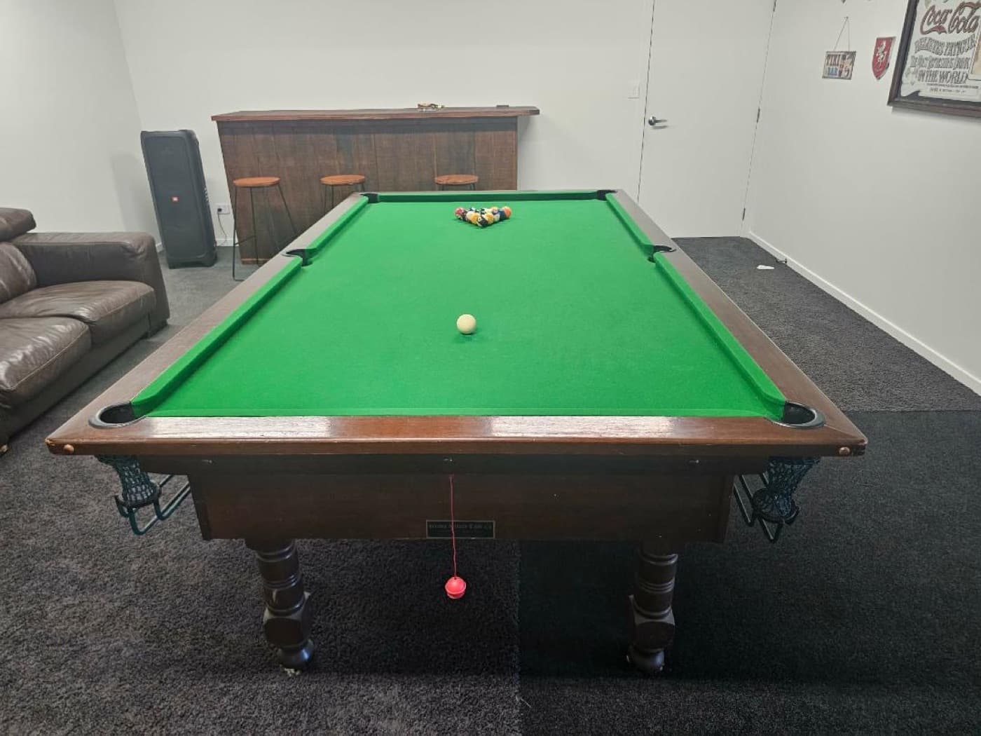 The full-size pool table, set up for a game
