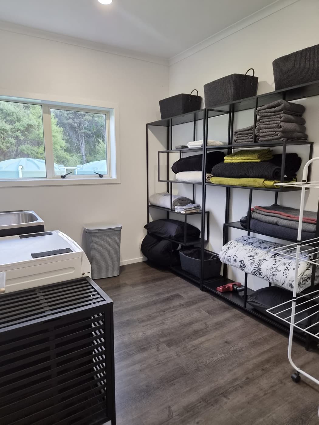 The laundry with open shelving, baskets and folded linen